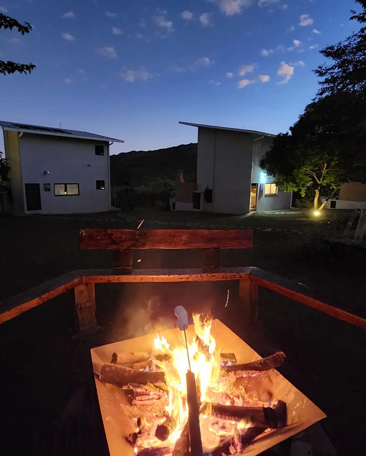 Fogueira acesa à noite na área comum, com as casas ao fundo